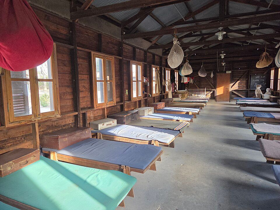 Inside the barracks at the Atlit Detention Camp with rows of beds