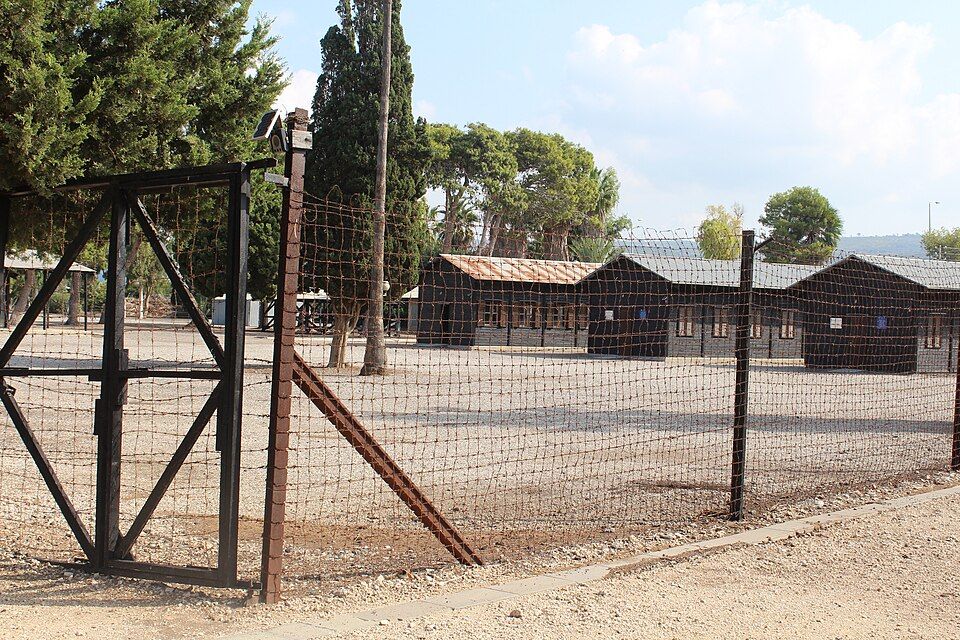 The fence and wooden barracks at the Atlit Detention Camp