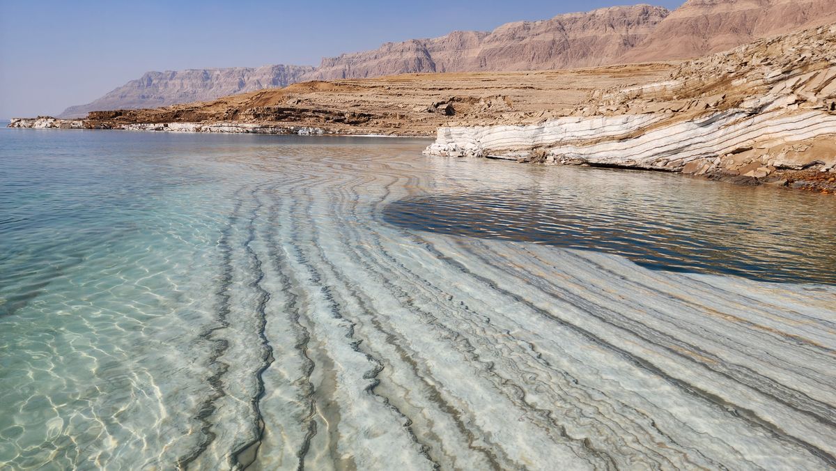 The Dead Sea with salt formations and desert cliffs