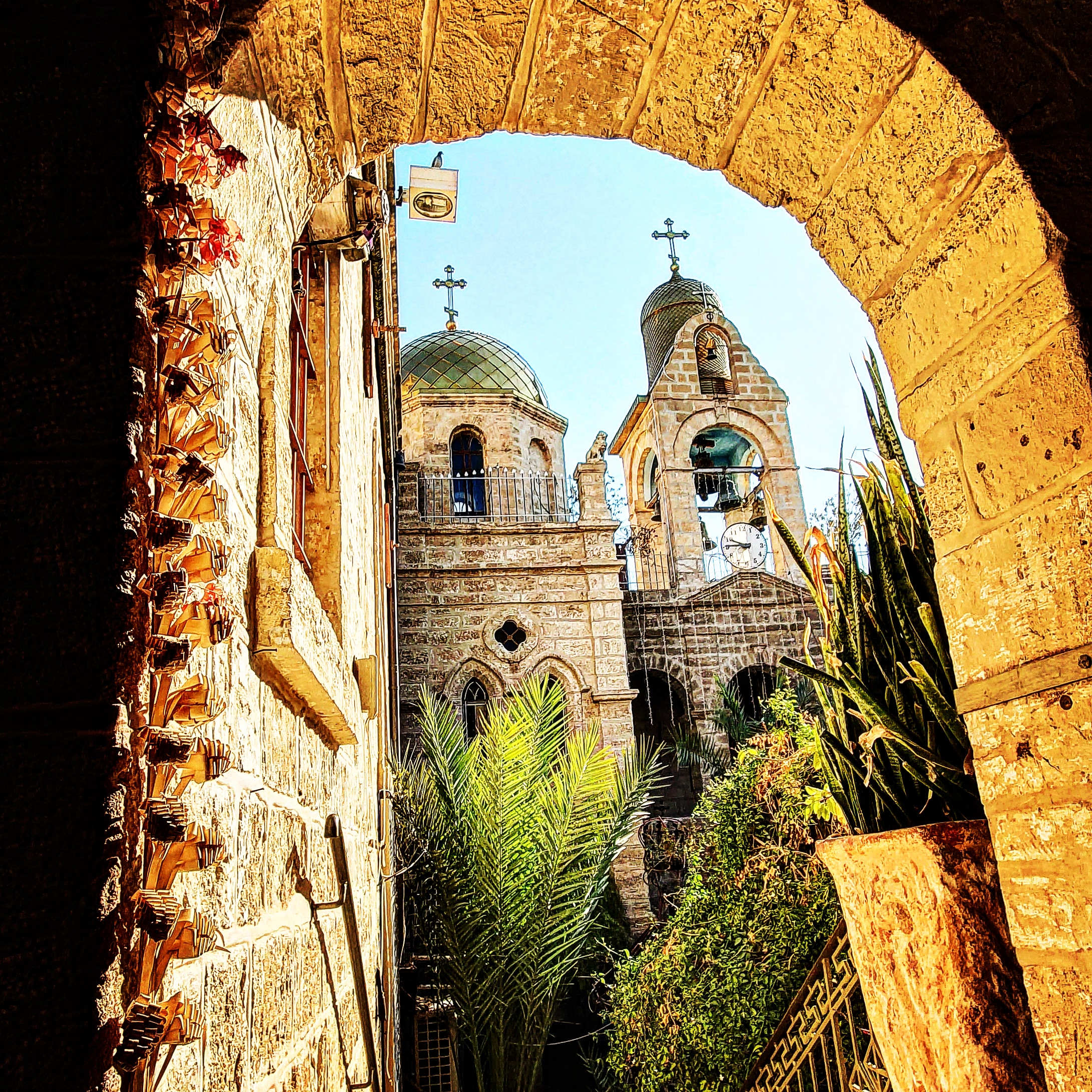 The Monastery of St. Gerasimus (Deir Hajla) seen through a stone arch with its domes and bell tower