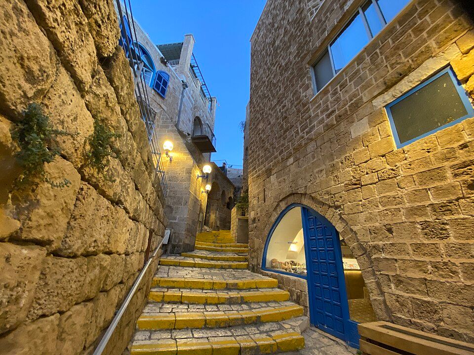 The narrow stone alleyways of old Jaffa at dusk with warm lantern light