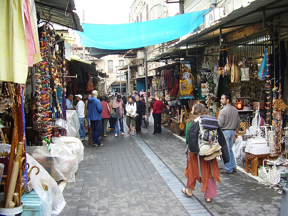 Shoppers browsing the narrow alleys of the Jaffa Flea Market