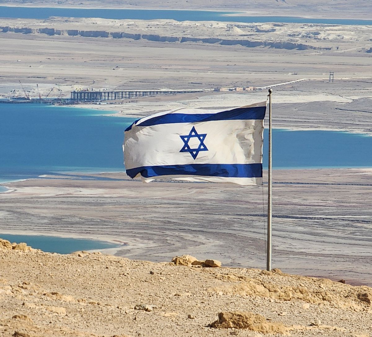 Israeli flag flying at Masada with the Dead Sea in the background