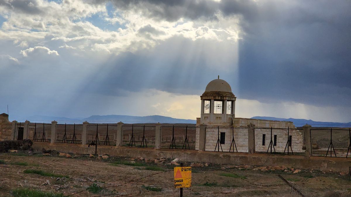 A church near Qasr el-Yahud with a Danger Mines warning sign and dramatic sunrays
