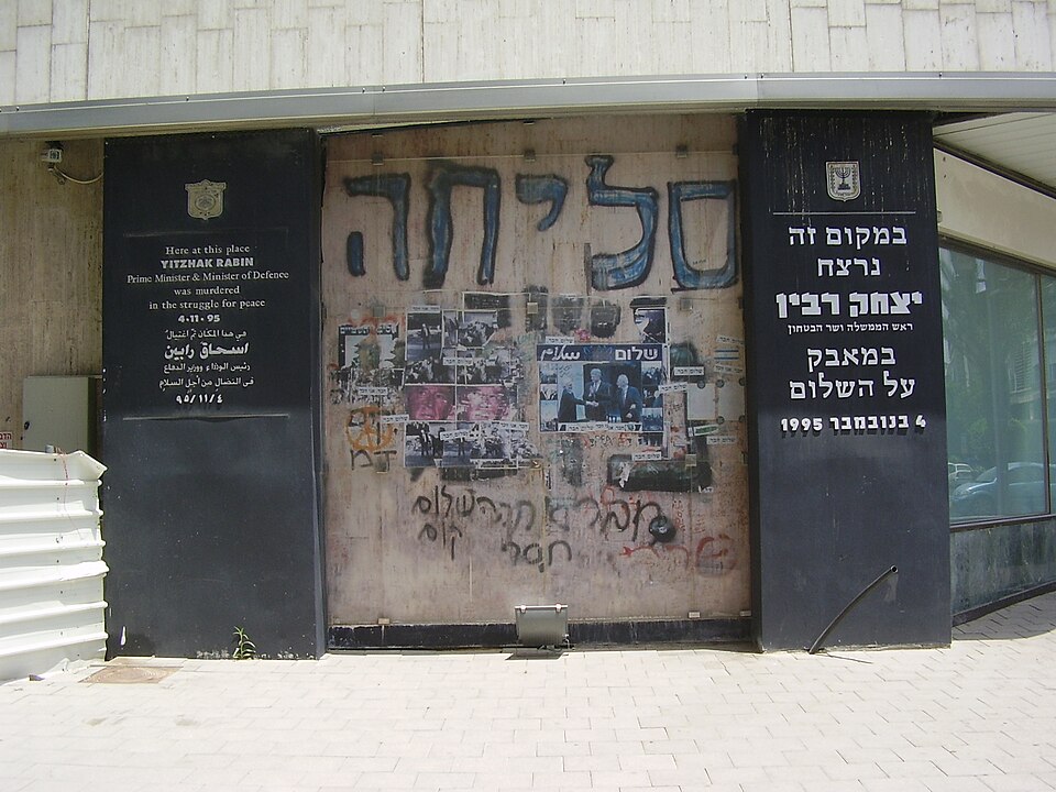 Memorial wall at the Rabin assassination site with the word Slicha and tributes