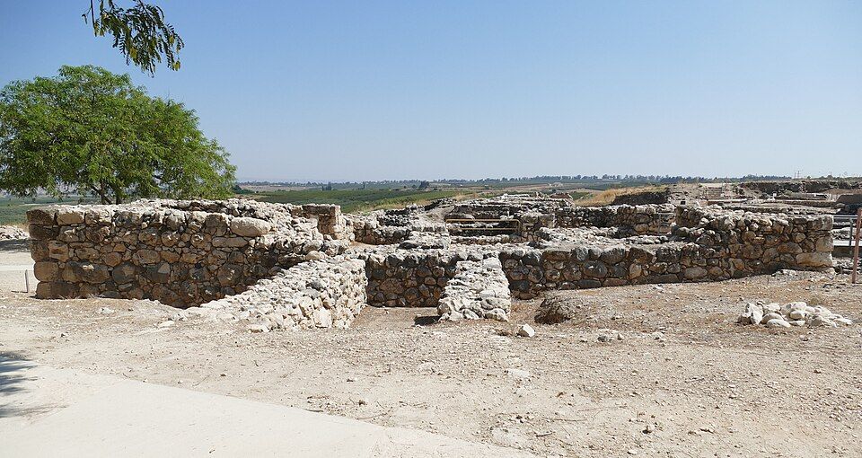 Ancient stone ruins at Tel Hazor with the Galilee hills in the background