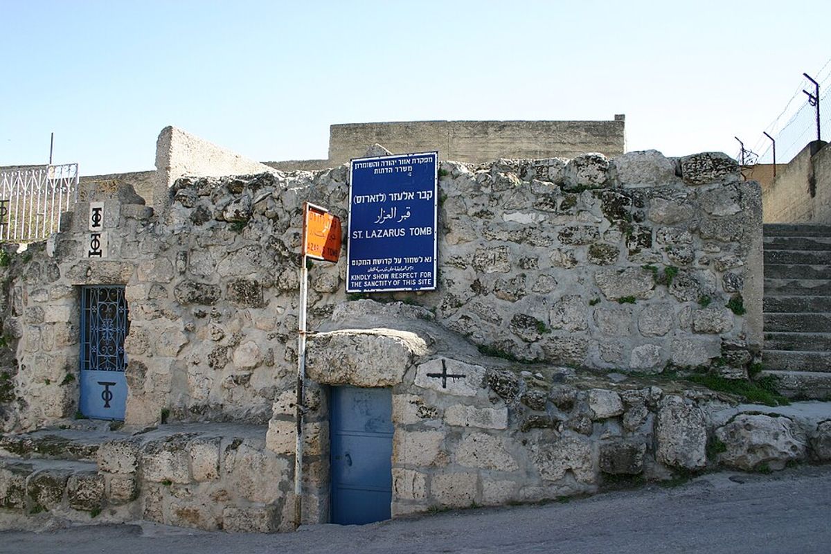 Entrance to the Tomb of Lazarus in Bethany with sign in Hebrew, Arabic, and English